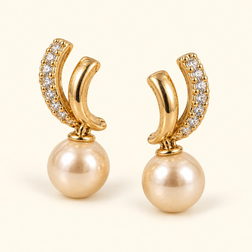 Aretes de doble curva y cuenta tipo perla, vista de estudio en ángulo