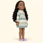 Muñeca Charlie fuera de su empaque, vista de tres cuartos con cabello negro rizado, vestido tejido y zapatos lilas.