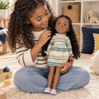 Escena ilustrativa de juego con una niña sosteniendo la muñeca Charlie Be My Bestie en su regazo.